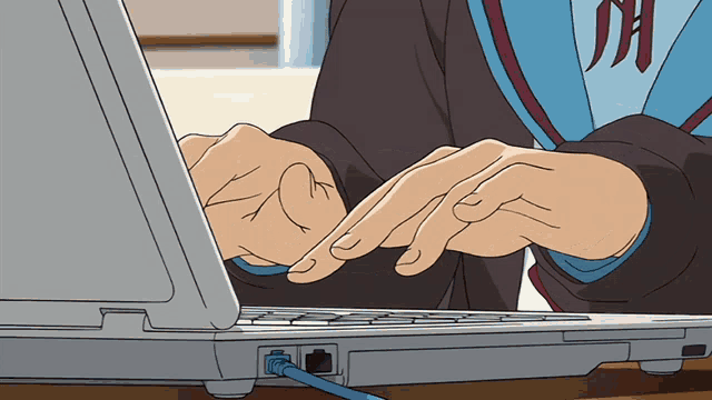 a person is rapidly typing on a laptop with a blue ethernet cord plugged in